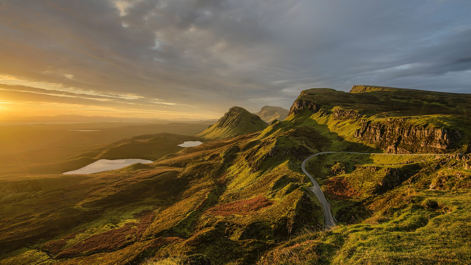 Light over green hills and a winding road