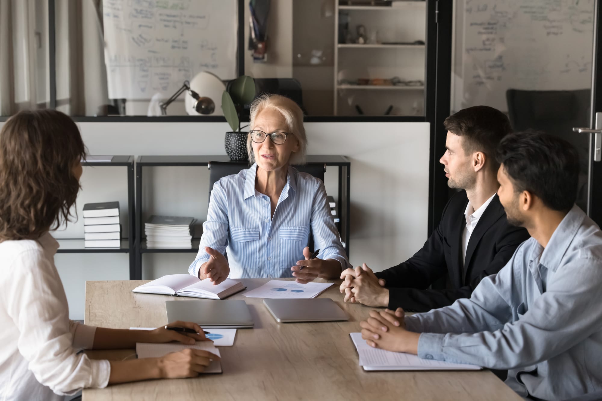 A manager talking with three colleagues around a table