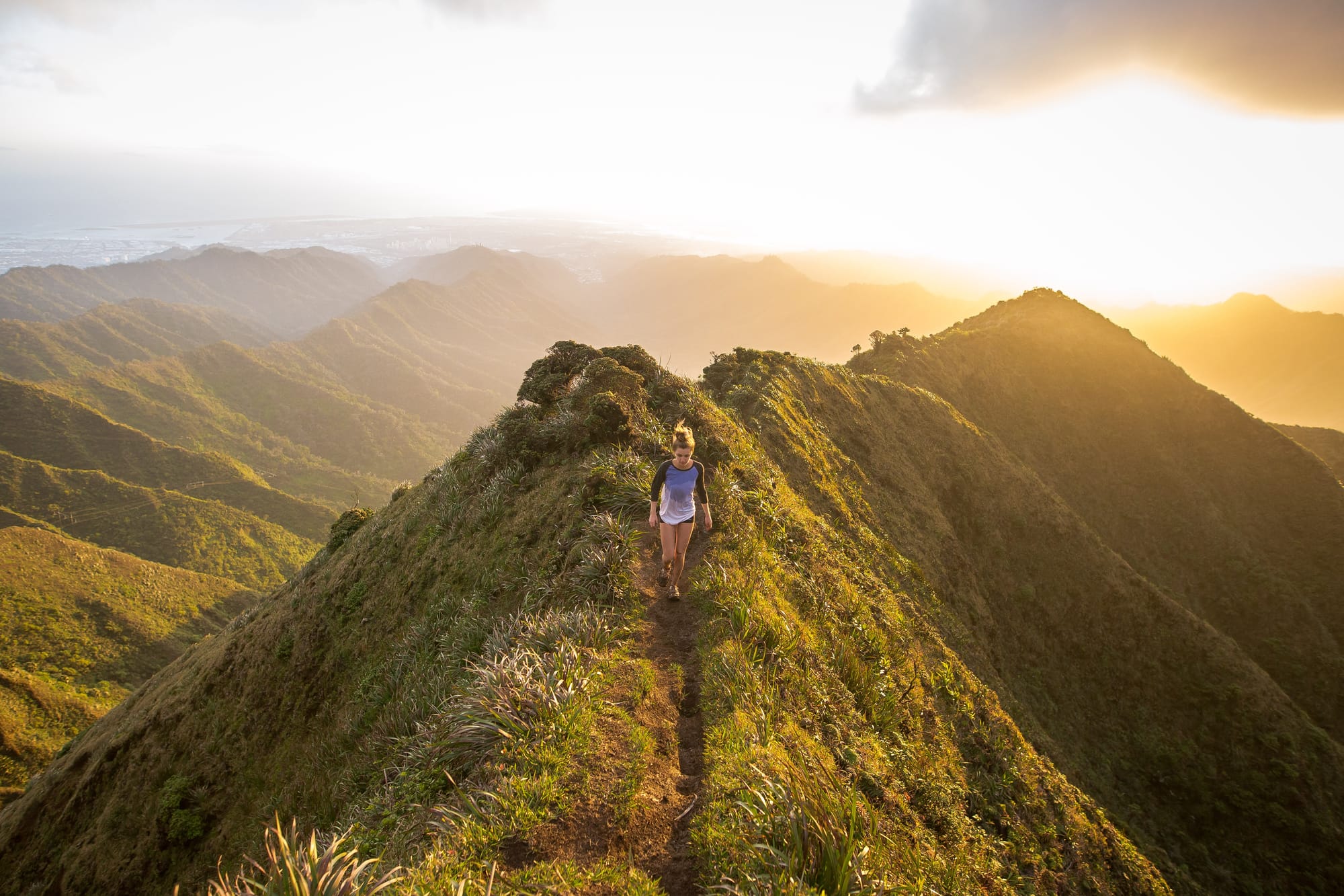 A walker on a narrow ridge path in early light